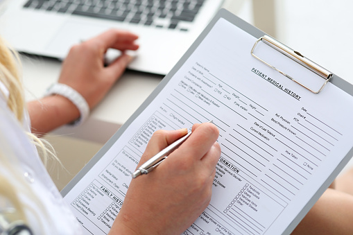 Woman filling out patient form for Downey Oral and Maxillofacial Surgery in Downey, CA