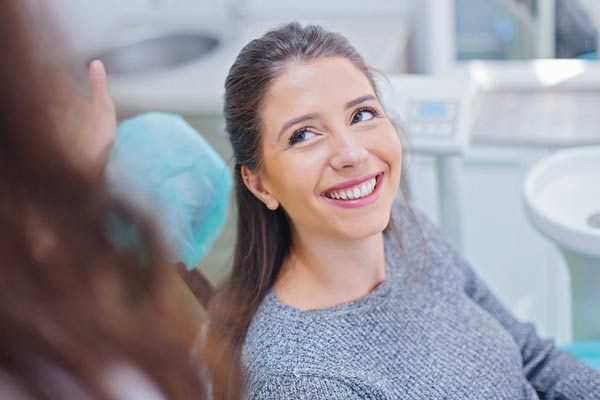 Woman smiling while visiting Downey Oral and Maxillofacial Surgery in Downey, CA